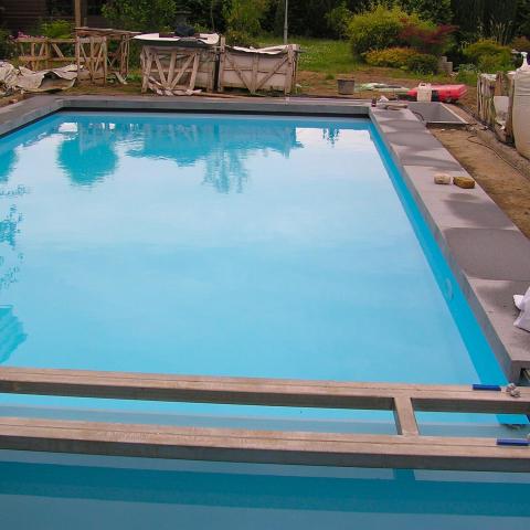 Pose de la margelle sur cette piscine extérieure rectangulaire
