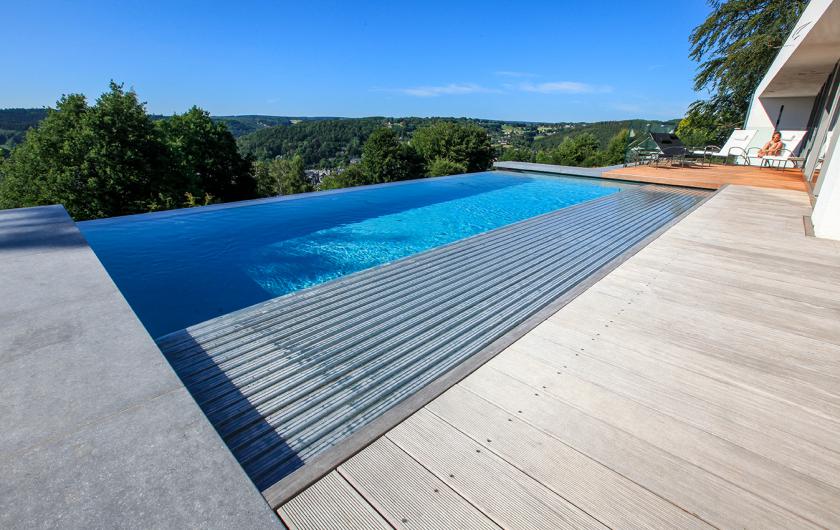 Couverture automatique pour cette piscine extérieure à débordement